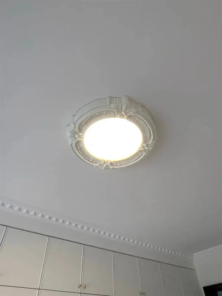 White ornate off-white carved decorbites french style ceiling light fixture with intricate floral detailing for bedroom decor