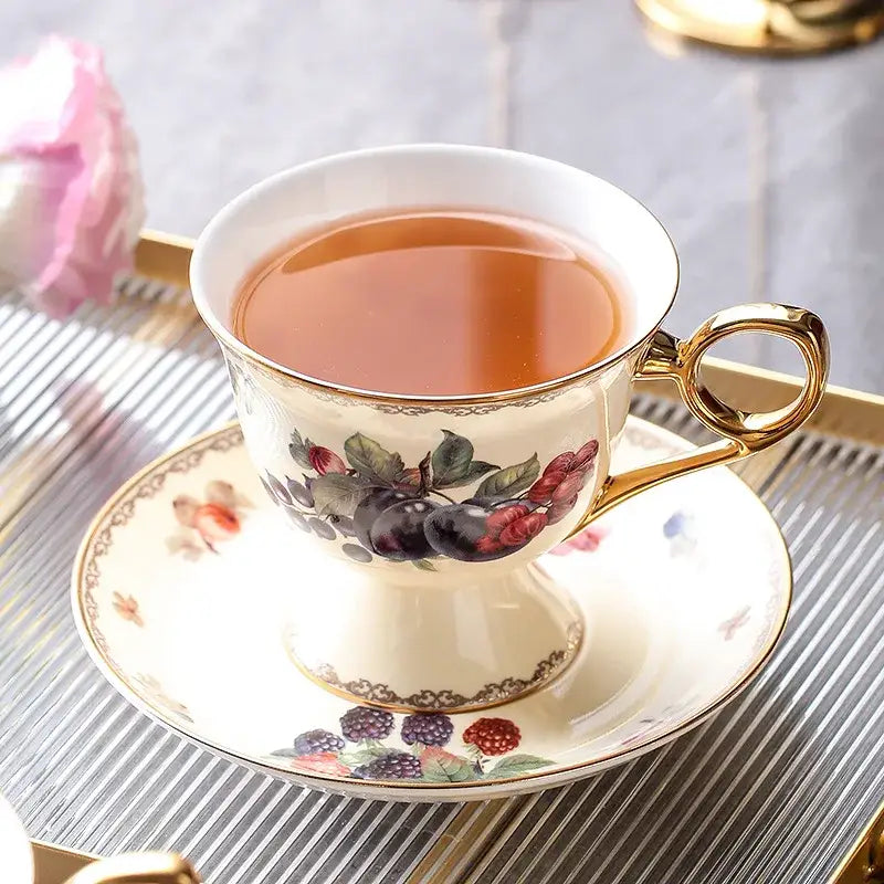 Elegant cream-colored bone china tea cup with gold trim and hand-painted berry motif from decorbites teaware set