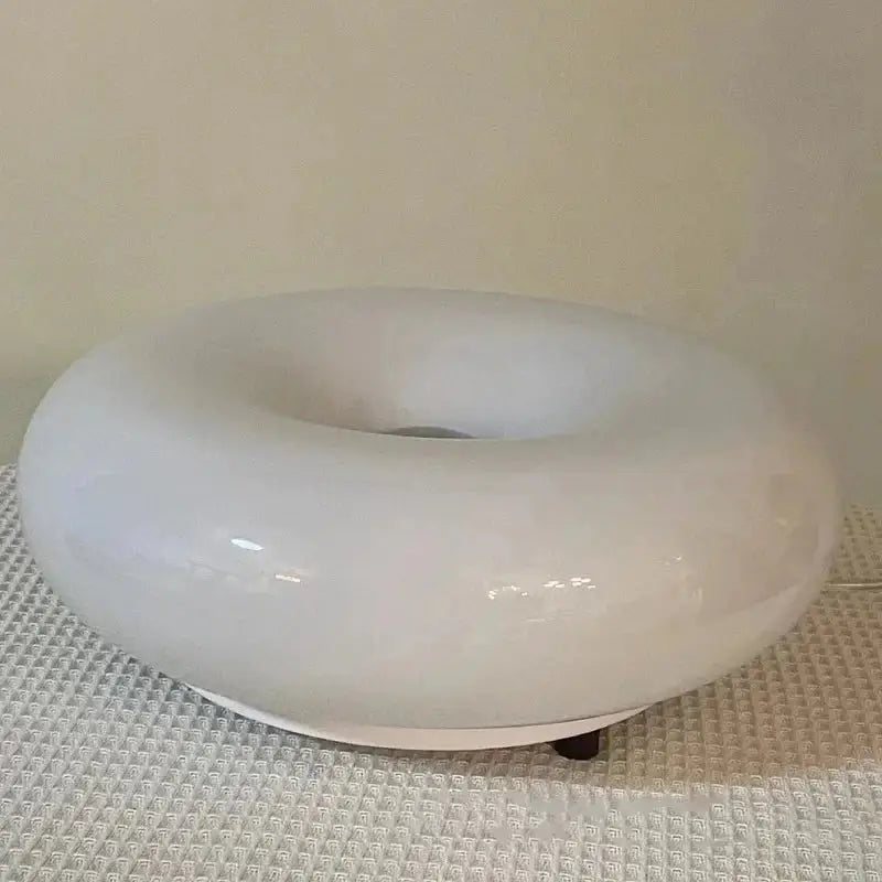 A sleek glossy white ceramic ring diffuser for a modern decorative wall lamp in french style bedroom lighting