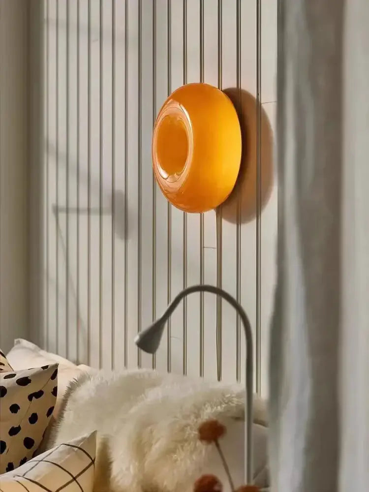 French style orange glossy ceramic decorative wall lamp featuring a vibrant translucent donut-shaped design for bedroom use