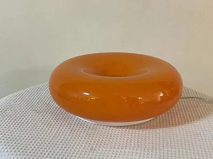 Glossy orange ceramic decorative wall lamp with a smooth translucent finish and white base for bedroom lighting