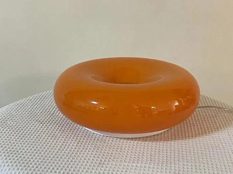 Glossy orange ceramic decorative wall lamp with a smooth translucent finish and white base for bedroom lighting