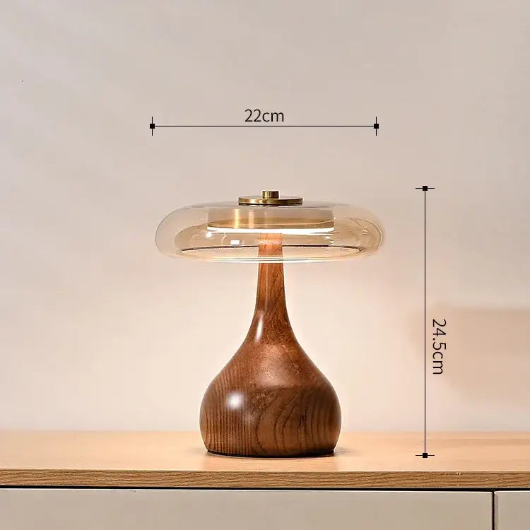 A sleek french style walnut table lamp with a warm brown wooden base and a translucent glass dome for bedroom lighting