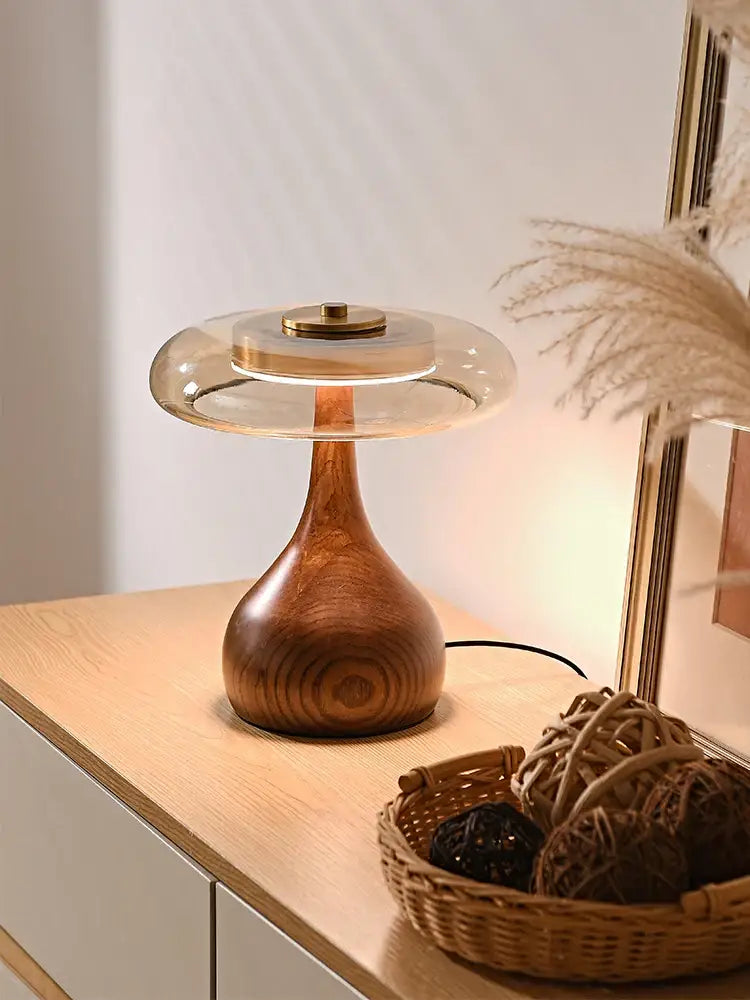 Warm-toned walnut table lamp with sleek curved base and translucent glass dome for bedroom lighting in French style
