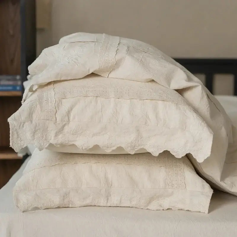 Stack of off-white embroidered pillowcases with lace trim from french vintage cream cotton linen bedding set decorbites cotton linen