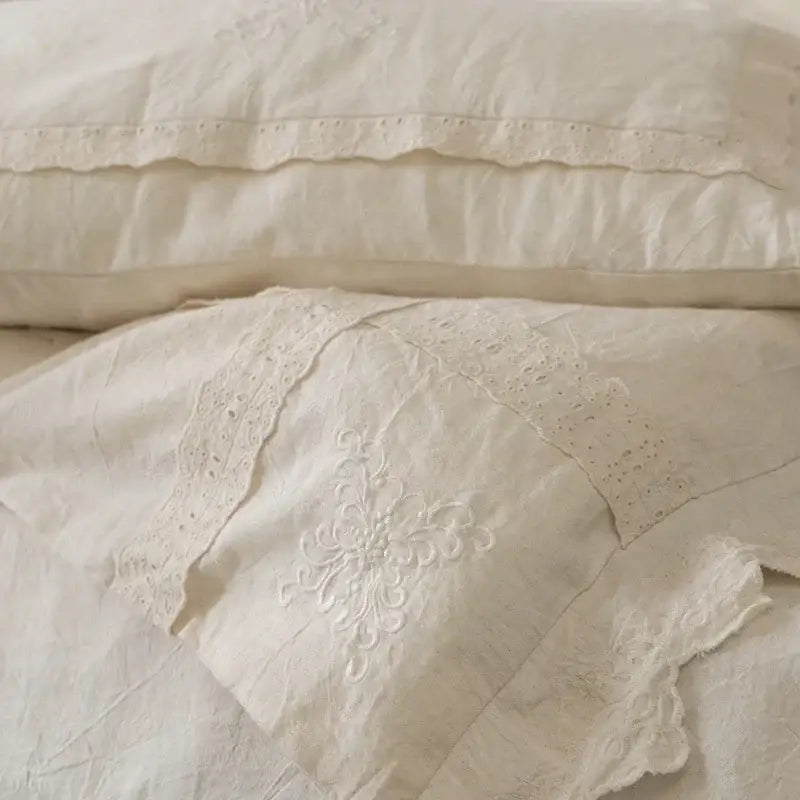 Off-white linen pillowcase with eyelet lace trim and floral embroidery in french vintage cream cotton linen bedding set