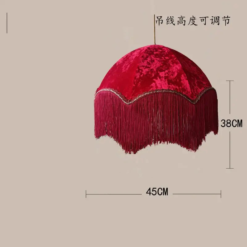 A plush deep red velvet beauvamp tassel pendant light with gold scalloped edge and cascading fringe for living room