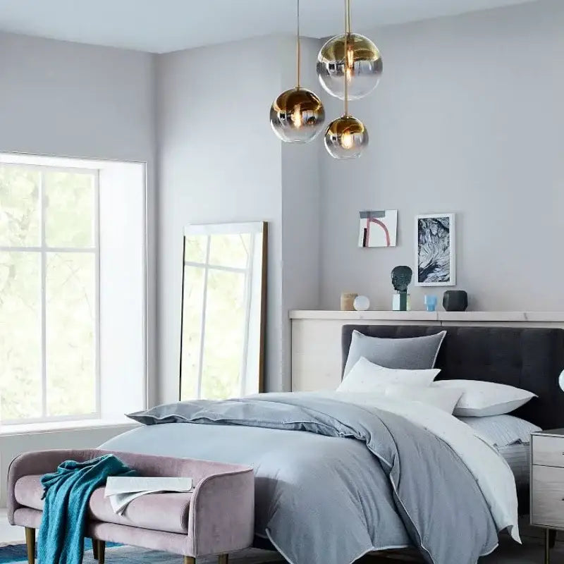 Modern gold and clear glass ball pendant light fixture hanging above bed suitable as decorbites glass ball pendant