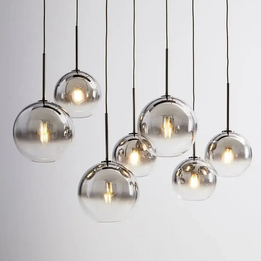 Set of seven frosted and mirrored glass ball pendant lights suspended by black cords for dining room decorbites pendant light