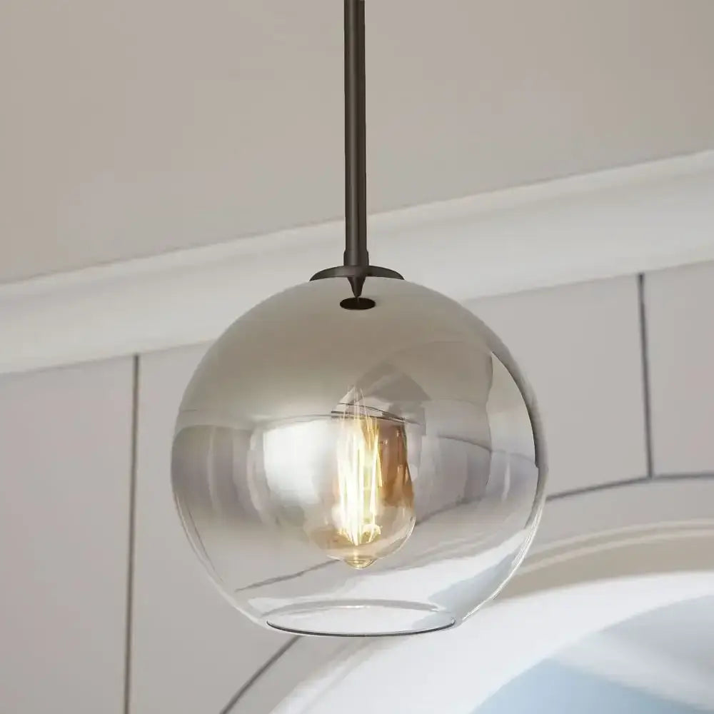 A sleek smoked glass ball pendant light with dark metal rod and exposed filament bulb for dining room decorbites glass ball