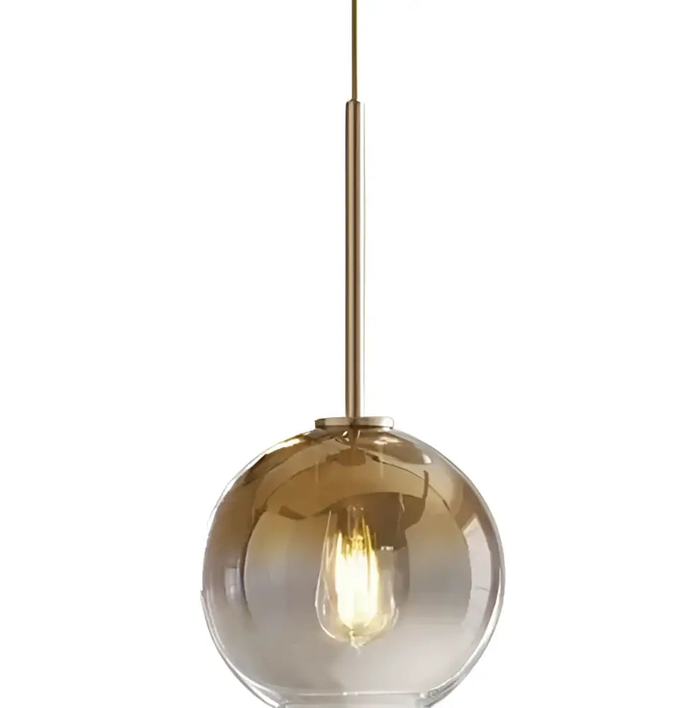 A sleek amber glass ball pendant light with brass rod and exposed filament bulb for dining room decorbites pendant light