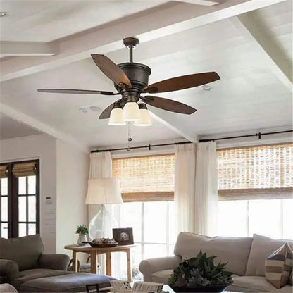 Dark bronze ceiling fan with five wooden blades and decorbites frosted glass bell shades for living room use