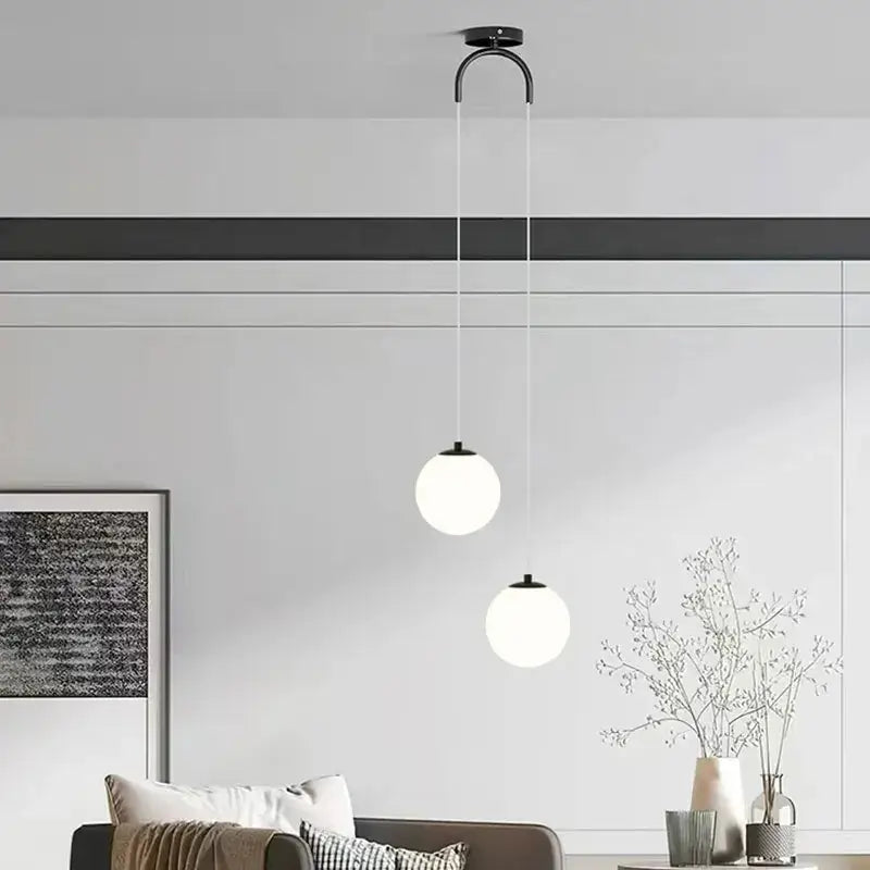 Modern black metal ceiling pendant light with two frosted white glass pendant spheres for dining room use