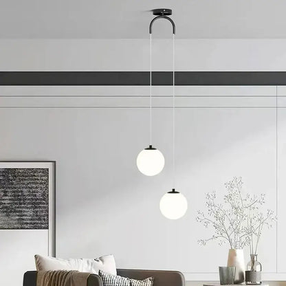 Modern black metal ceiling pendant light with two frosted white glass pendant spheres for dining room use