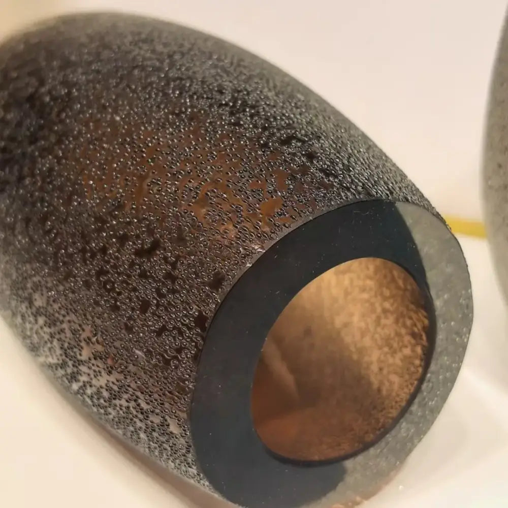 Black textured cylindrical pipe with rough speckled exterior and smooth inner bore for decorbites frosted glass vase trio