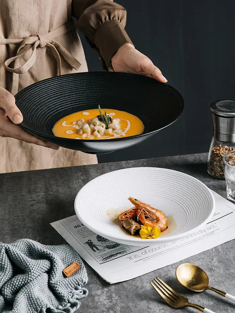 Black ceramic bowl with concentric ridges holding orange soup from decorbites frosted glaze ceramic dining set of 4