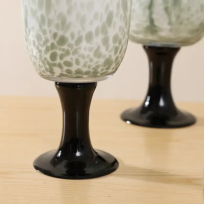 Elegant green and white speckled glass wine goblets with sleek black stems featuring dot texture decorbites dot texture design