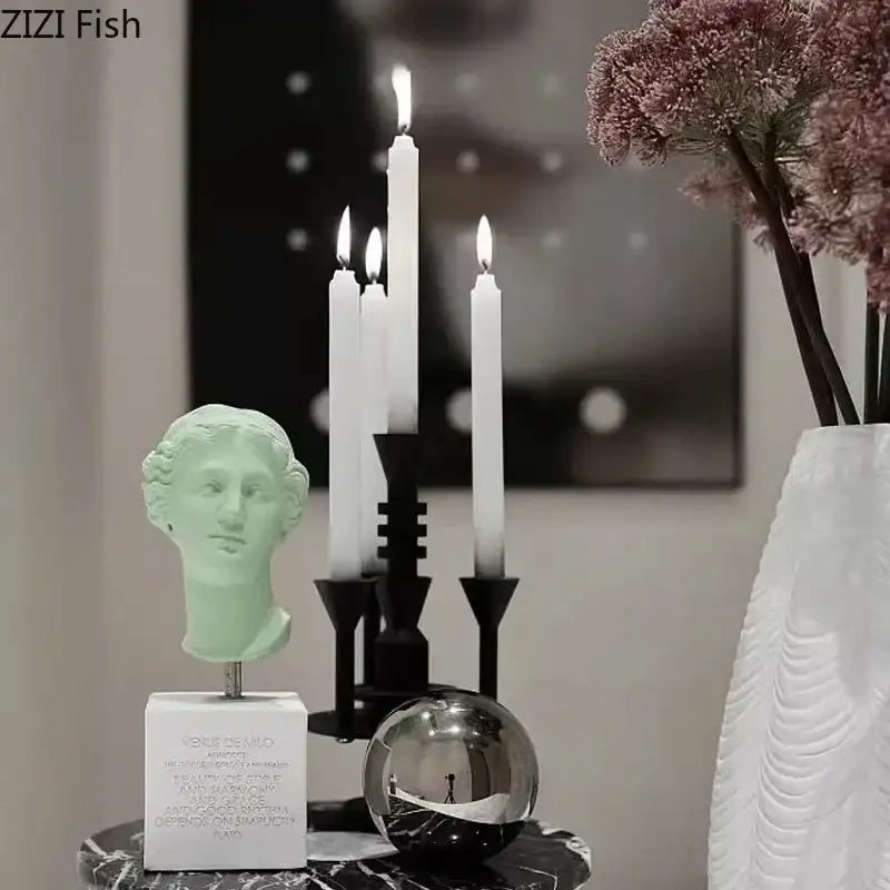 A pale green sculpted bust atop a white base serving as a decorbites frosted metal candle holder for romantic dining decor