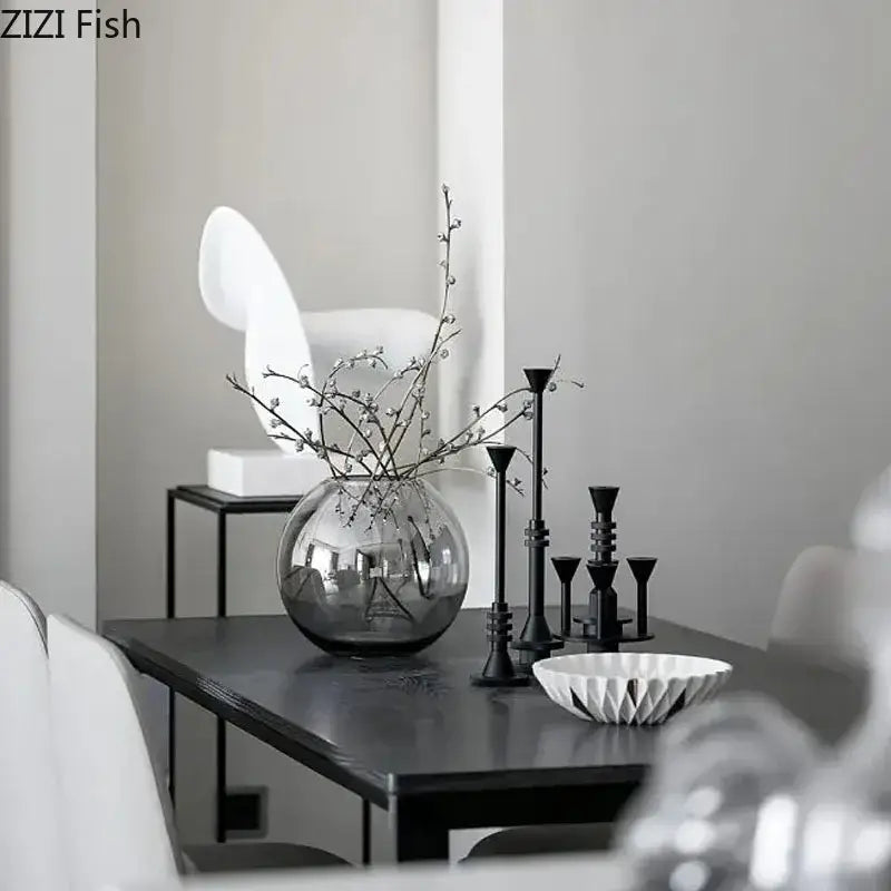 A sleek round glass vase with reflective surface and bare branches complements decorbites frosted metal candle holder decor