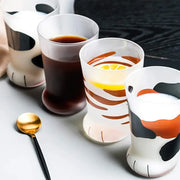 Set of four frosted glass shot glass mugs with orange and black cat paw decorbites cat paw designs on white base