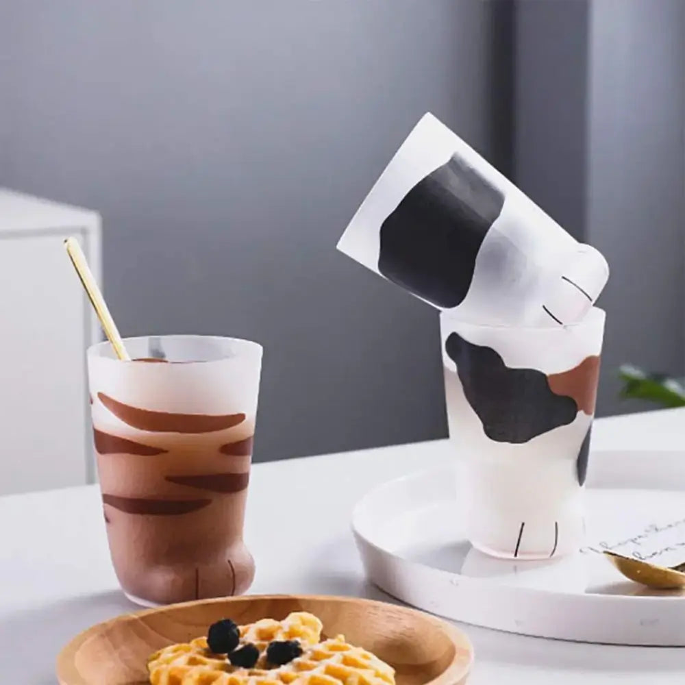 A frosted glass shot glass with playful black and brown cow print decorbites cat paw design for kitchen decorbites cat paw shot