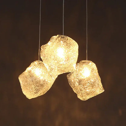 Three irregular frosted textured ice cake glass pendant lights with warm illumination for dining room decorbites pendant light