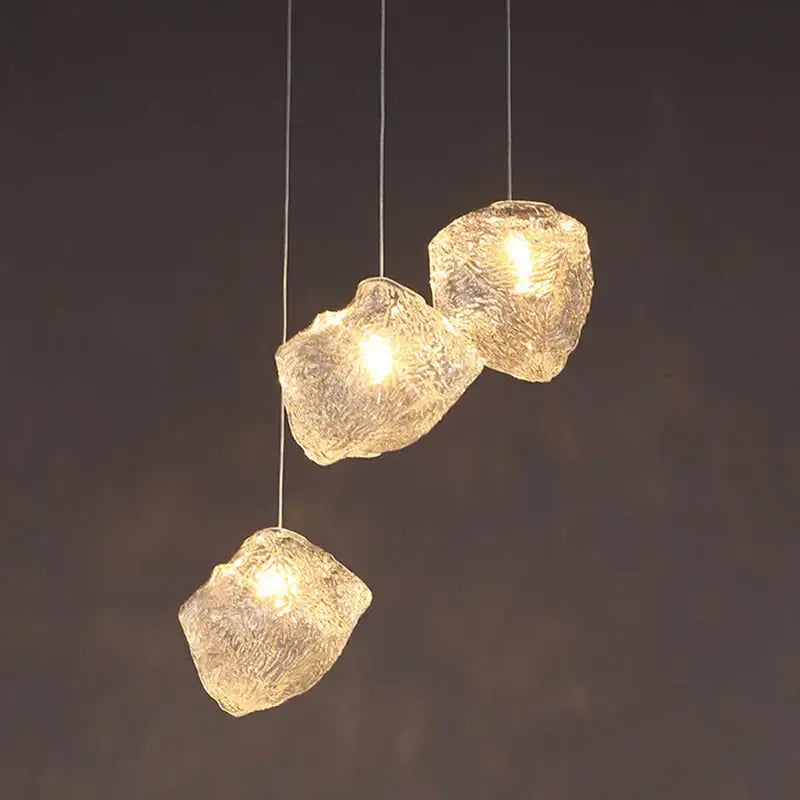 Three amber-hued translucent ice cake glass pendant lights with frosted textured decorbites ice cake design for dining room