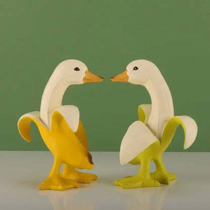 Funny white banana duck sculpture featuring two white duck figurines with orange beaks inside yellow banana peels for living room decor