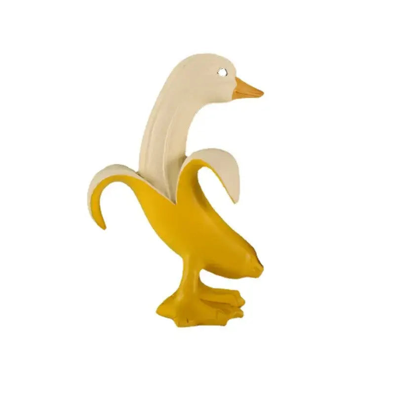 A whimsical white duck sculpture with an orange beak and feet emerging from a peeled yellow banana banana duck sculpture