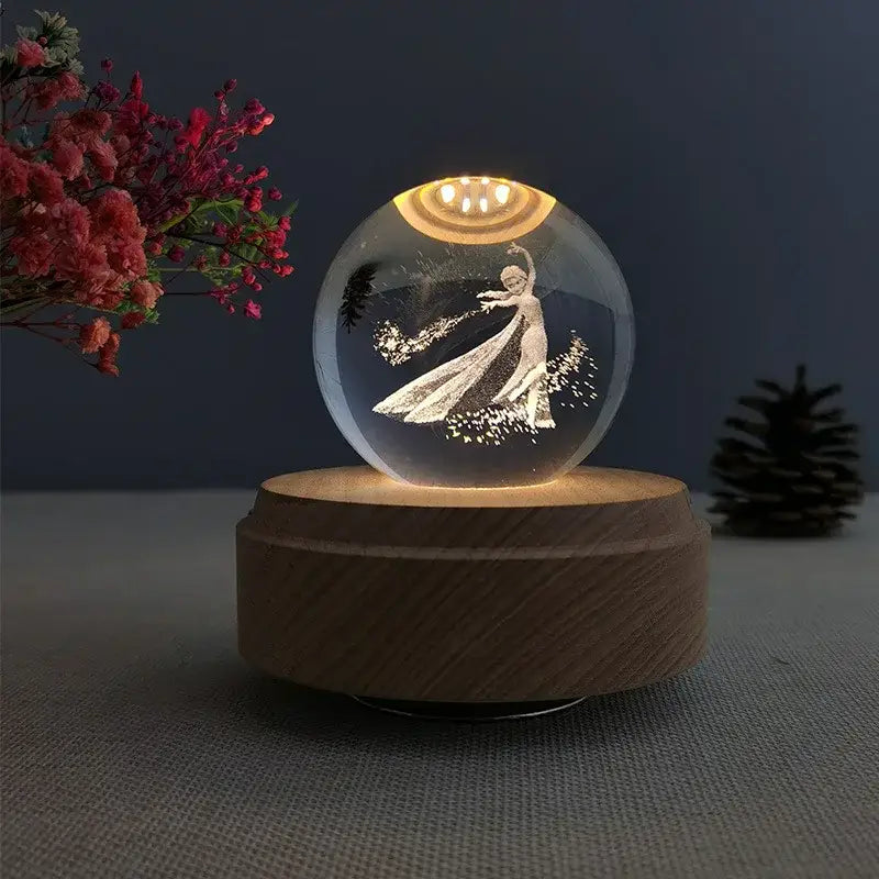 A glowing transparent crystal ball music box featuring an engraved elsa figure on a warm wooden rotating base