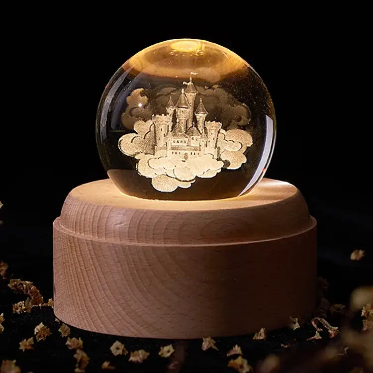 A glowing transparent crystal ball music box with an engraved castle on clouds on a light wooden base