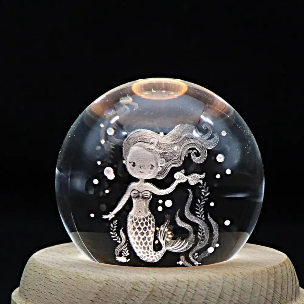 Galaxy crystal ball music box with clear spherical glass featuring an engraved mermaid surrounded by aquatic plants and bubbles