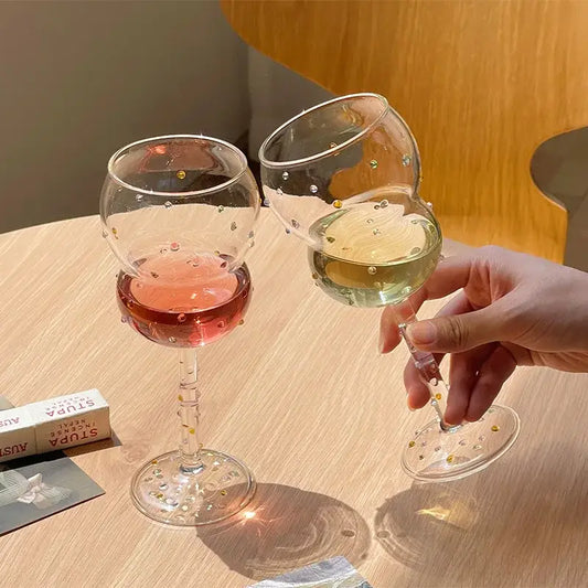 Clear glass gem spark coupe goblets with gold bead embellishments filled with pink and pale yellow liquids