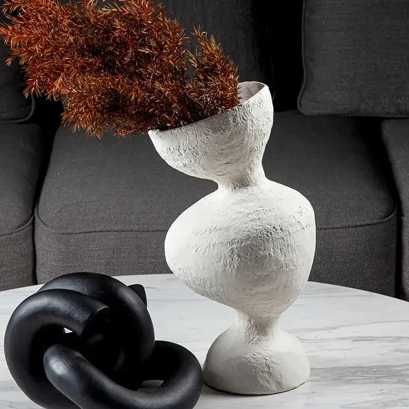 White textured ceramic geometric abstract vase with organic sculptural form holding dried brown foliage for decorbites decor
