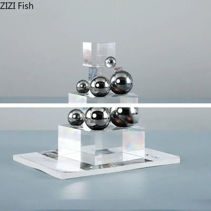 Shiny chrome silver ball desk ornament displayed on tiered transparent acrylic blocks for geometric decorbites crystal ladder