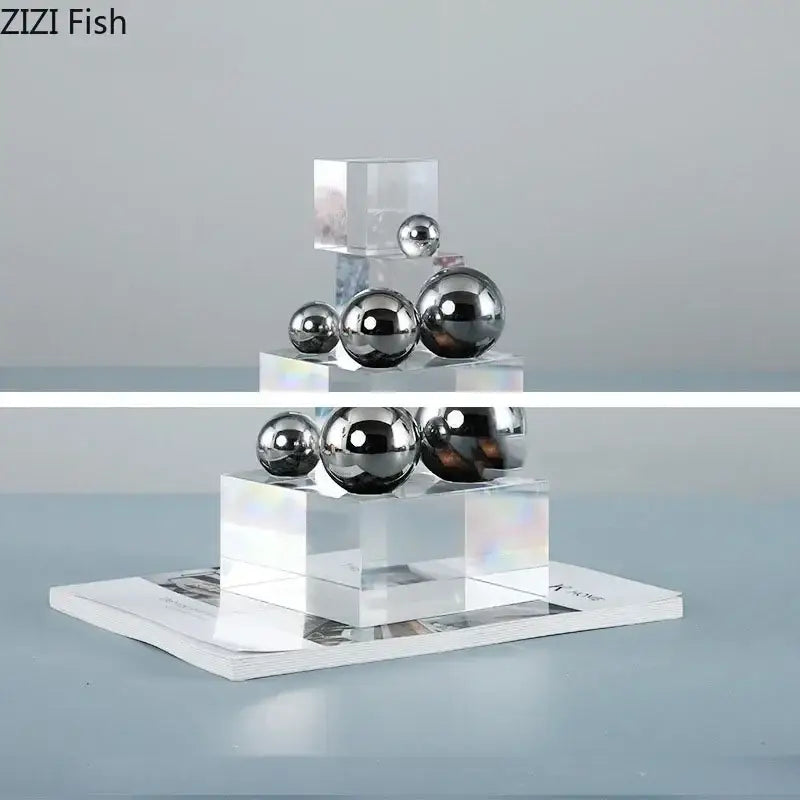 Shiny chrome silver ball desk ornament displayed on tiered transparent acrylic blocks for geometric decorbites crystal ladder