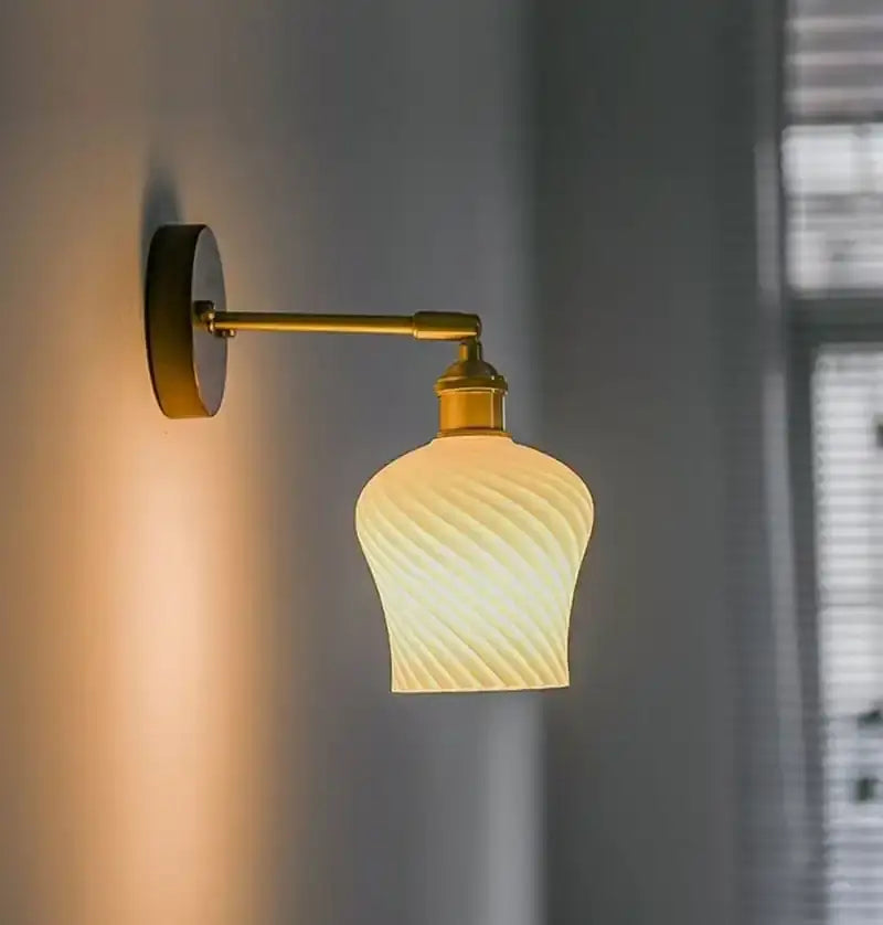Geometric amber and cream glass pendant light with twisted design and brass-finished arm for dining room use
