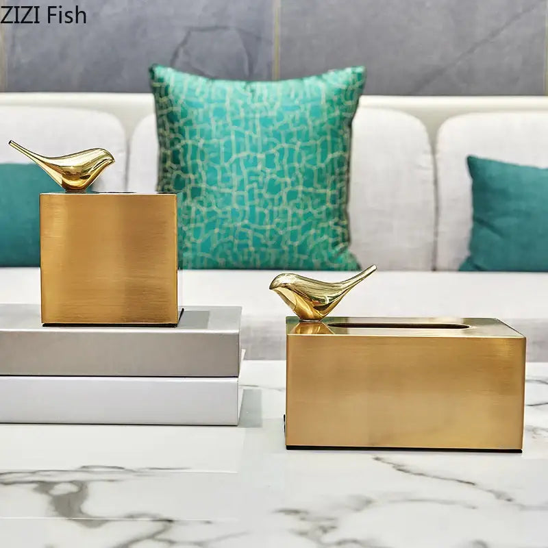 Gold-colored geometric animal brass color tissue box with minimalist design and small bird figurine for living room decor
