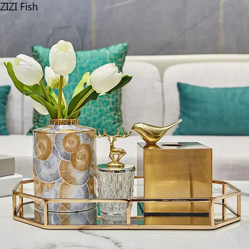 A tall cylindrical vase with gold rim and silver gray bronze patterns holding white tulips for decorbites brass color tissue box living room decor