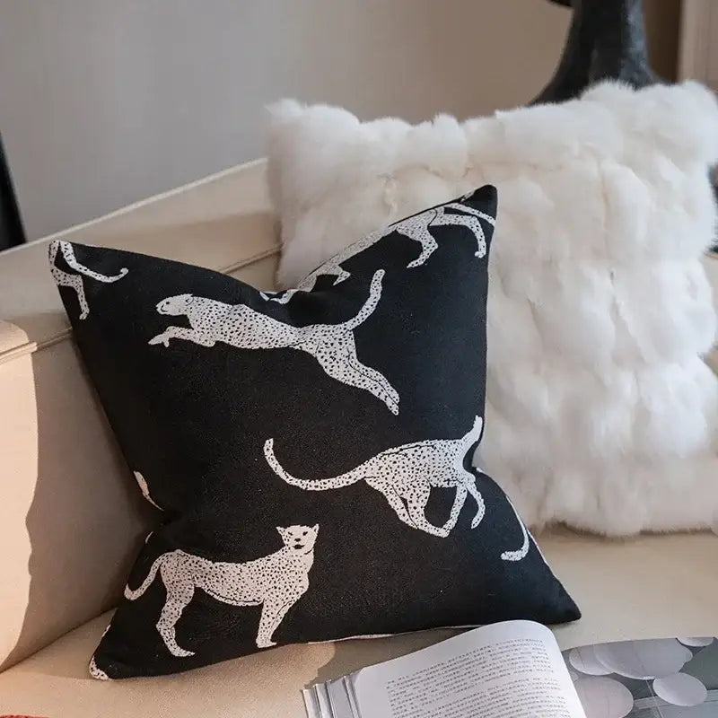 Black square pillow cover with white embroidered leopards in motion part of geometric black and cream jacquard cover set for living room