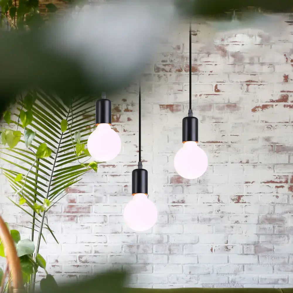 Geometric black decorbites iron 3-light chandelier pendant with exposed bulbs hanging against white brick wall