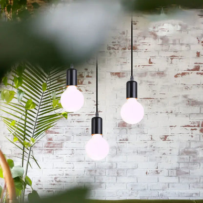 Geometric black decorbites iron 3-light chandelier pendant with exposed bulbs hanging against white brick wall
