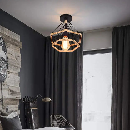 Industrial-style black cage iron pendant light with hexagonal woven rope frame and exposed edison bulb for dining room
