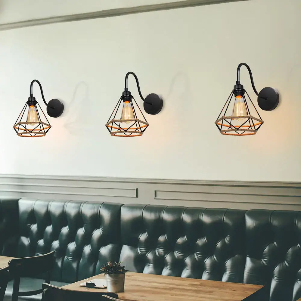 Three black wrought iron cage iron pendant wall sconces with geometric diamond cage and exposed filament bulbs