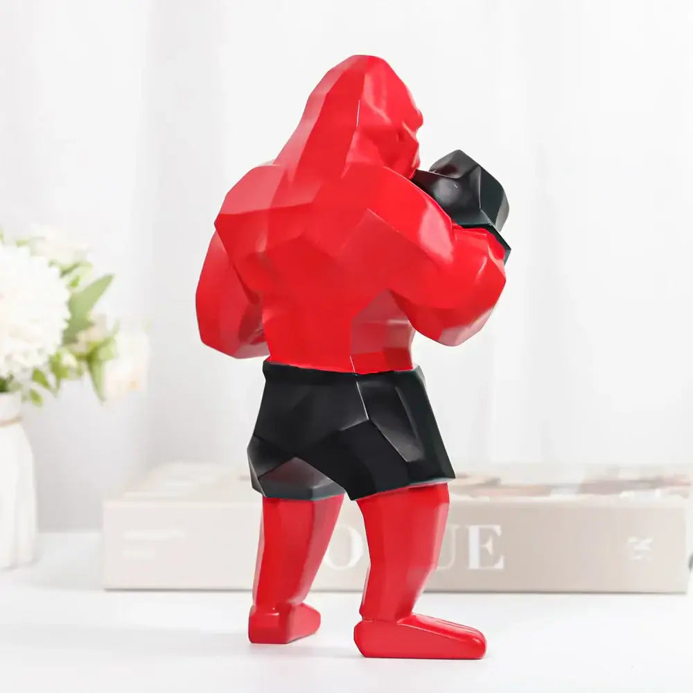 Red and black geometric-style muscular boxer figurine paired with decorbites king kong black and gold sculpture for office decor