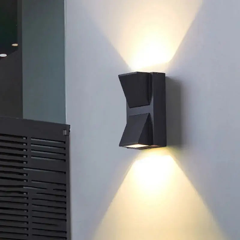 Geometric black led outdoor wall light with matte finish and angular design casting warm directional light