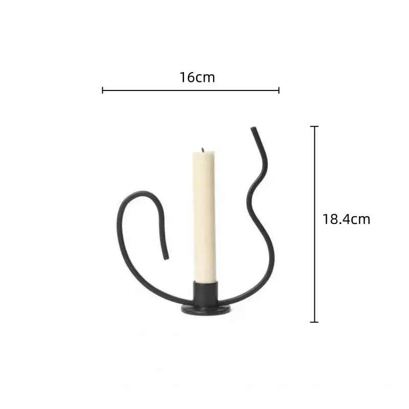 Geometric black metal candlestick candelabrum with curved wrought iron design holding an off-white candle centerpiece