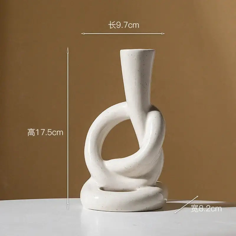 A minimalist white ceramic knot candle stand with abstract loops by Decorbites for modern home decor