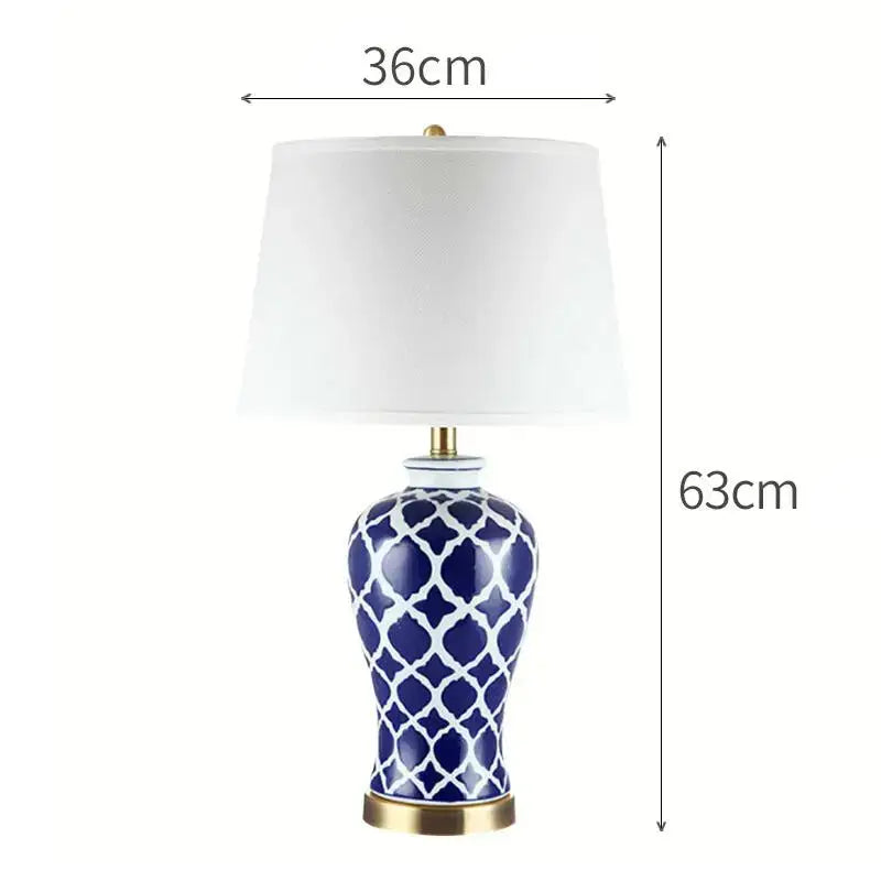 Navy blue ceramic bedside table lamp with white geometric lattice pattern cream fabric shade and gold base details