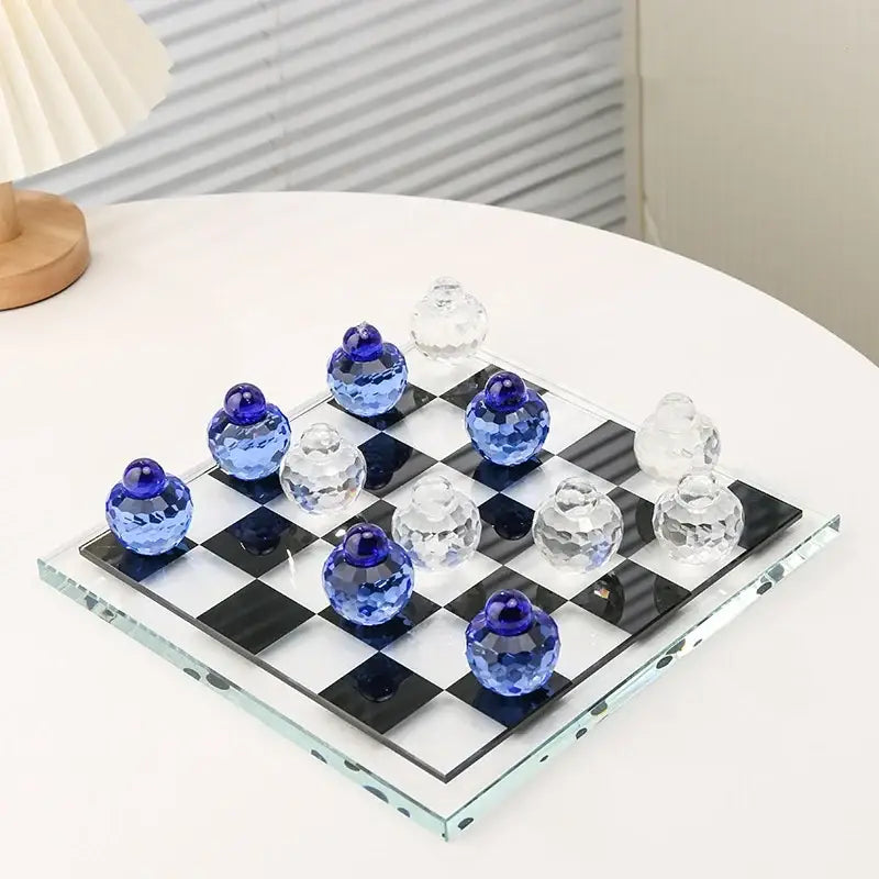 A geometric blue and clear glass chess set with faceted pieces on a black-and-white checkered board for living room decor